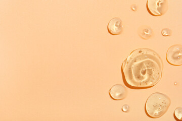 Samples of transparent cosmetic gel on beige background, closeup