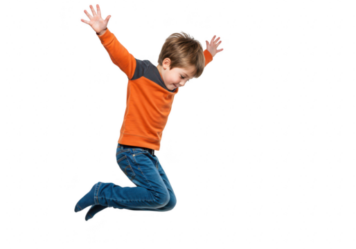 A young boy in an orange shirt and blue jeans jumping with arms raised, isolated on transparent background