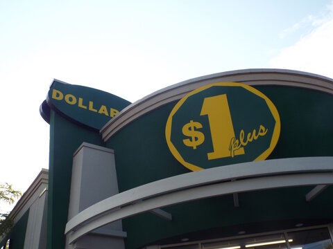 Ottawa, ON, Canada, June 11, 2025: A "Dollar Plus store", prominent signage. The sign is green with a large yellow logo featuring a stylized "$1 plus" and a green circle on Carling Avenue.

