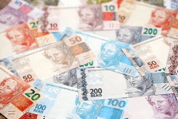 Brazilian reais banknotes. The current Brazil real money bills lies on table in big amount