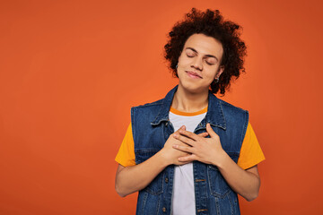 Expressing joy with youthful style and charm against a vibrant orange background