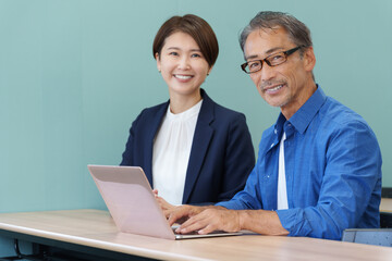 Fototapeta premium パソコン教室に通うシニアと教える講師