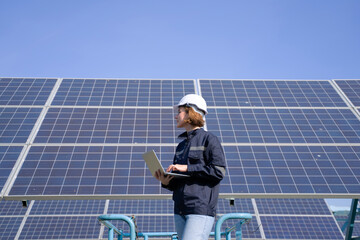 Engineer is working at solar farm.