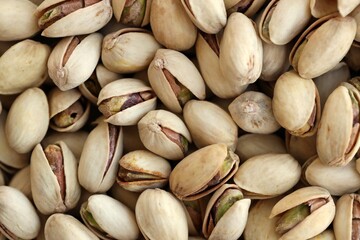 Many tasty unpeeled pistachios top view flat lay background pattern