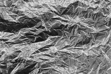 Silver crumpled foil texture on flat surface