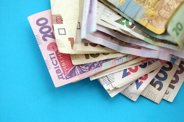Ukrainian money bills on light blue paper background