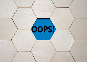 Oops symbol. Concept word Oops on wooden comb puzzle. Beautiful blue background. Business and Oops...