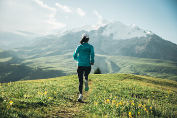 Trail runner running on the high altitude grassland mountain top trail