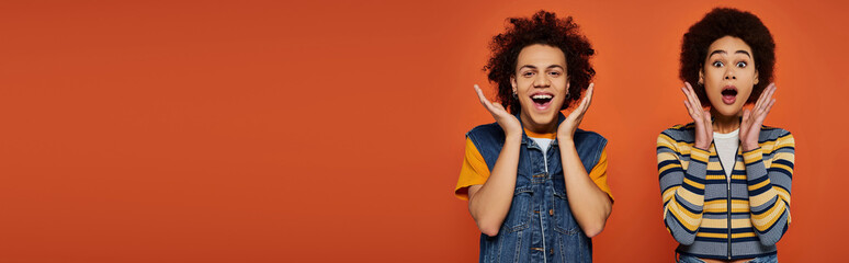 Young individuals with curly hair express excitement in a vibrant and colorful setting
