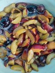 Sliced Plums glisten in a bowl, ready to be transformed into delectable jam. The fruit's juicy sweetness awaits its journey into a cherished homemade treat
