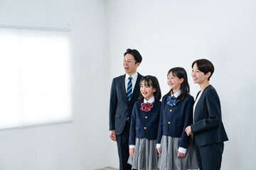 スーツを着た男女と制服を着た女の子二人