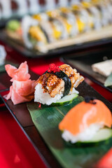 a nigiri is seen on a red table at a restaurant