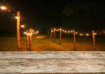 Wooden table top on blur tent camping travel tent at night.Drink and party concept.For montage product display or design key visual layout.View of copy space.