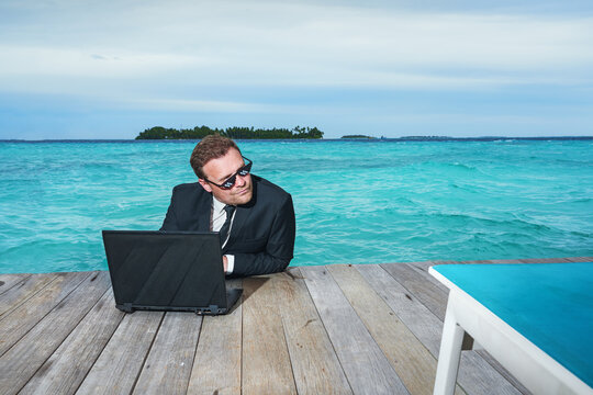 Remote online working on summer luxus sea beach. Business man with laptop during tropical beach vacation. Crazy comic businessman success concept.
