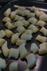 A batch of uncooked potato gnocchi sits on a baking sheet, ready to be prepared in a kitchen...