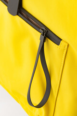 details of seam joints, fasteners and fasteners, yellow backpack made of thick fabric, insulated