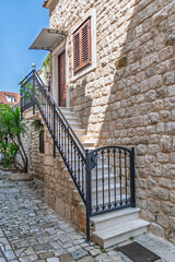 Beautiful stone staircase with an ornate wrought iron railing leading to the entrance of an old...