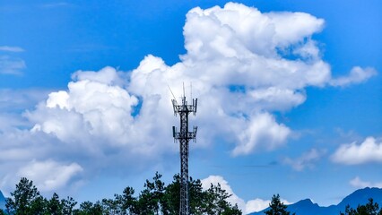 Cell Phone Tower in Rural Forest Landscape with Blue Sky and Clouds - Aerial Drone Shot