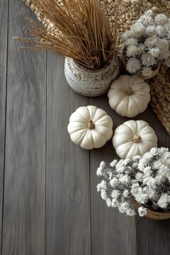 Minimalist fall white and sage pumpkins arranged on a grey wooden floor mums and dried wheat in ceramic pots