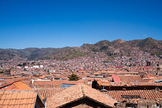 Ein weites Panorama von Cusco, das die schier unendliche Weite der charakteristischen roten D&auml;cher und der sich an die H&uuml;gel schmiegenden Bergstadt unter blauem Himmel zeigt