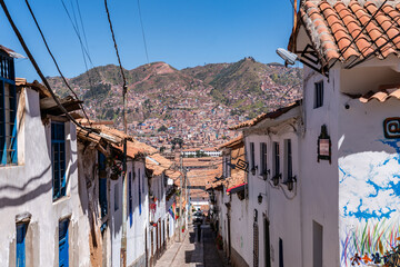 Blick über eine traditionelle Gasse in Cusco, Peru, mit Panoramablick auf die Stadt und die...
