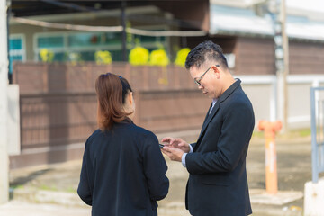 Real estate agent or manager discussing blueprint plan with digital tablet on construction site...
