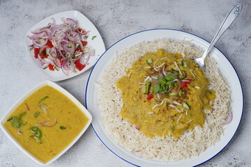 Dal Chawal with the bowl of dal, raita and salad isolated  on white background