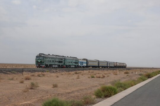 Passenger Train Crossing Desert Terrain in Arid Landscape
