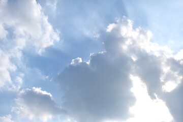 sunlight spreading from dark rain cloud floating on sky in afternoon