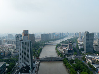 An expansive city view showcases towering buildings and a wide river flowing through a vibrant...