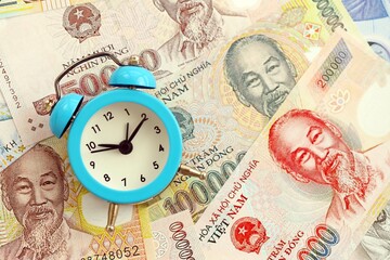 Vietnamese dong currency money bills and alarm clock. The concept of time management and income