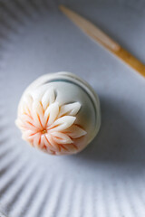 A piece of delicious Japanese confectionery on off white ceramic plate on wooden table.