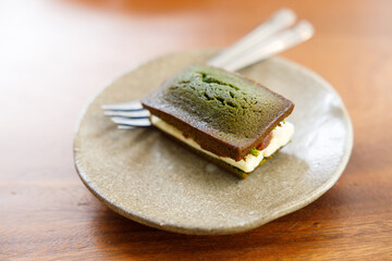 A piece of Cheese and Matcha and red bean paste financier, small French almond cake, on wooden...