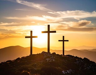 Three crosses on a mountaintop at sunset