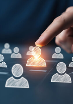 Hand selecting a glowing illuminated person icon from a group of abstract human figures representing talent acquisition and recruitment