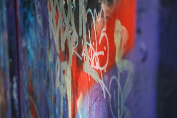 Prompt: Side perspective of a graffiti wall fading into the distance, sharp focus in the foreground with vibrant colors, background softly blurred for depth.
