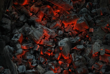 Macro close-up of glowing hot embers, shimmering orange and red textures with sparks of heat and...