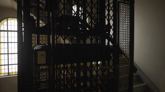 Old vintage elevator in a historic building with classic metal details and folding doors. Perfect for concepts of nostalgia, architecture and heritage.