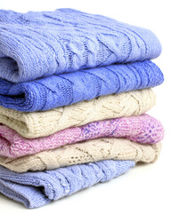 Cozy folded sweaters in pastel colors symbolize warmth and care at end of long day