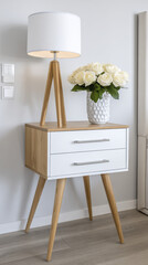 Modern wooden side table with lamp and vase of white roses adds elegance to room, reflecting care in design and end of busy day