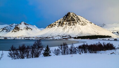 Obraz premium Majestic Snow-Capped Mountain Overlooking Icy Lake in Winter Landscape