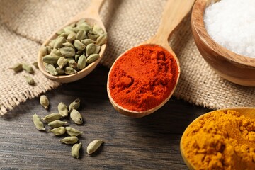Different aromatic spices on wooden table, closeup