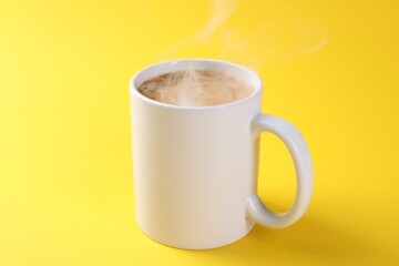 Aromatic coffee in cup on yellow background, closeup. Mockup for design