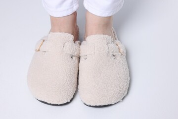 Woman in stylish white slippers on light floor, closeup