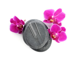 Acupuncture needles, orchid flowers and spa stones isolated on white, top view