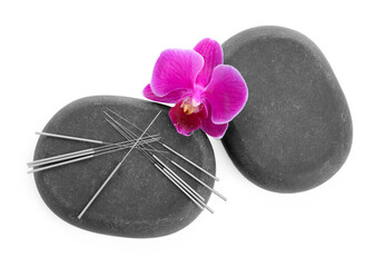 Acupuncture needles, orchid flower and spa stones isolated on white, top view