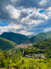 Obraz premium Scenic Scanno village nestled within Abruzzo mountains, revealing verdant landscape beneath brooding clouded sky