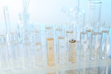 Glass test tubes with clean and dirty water on blurred background, closeup