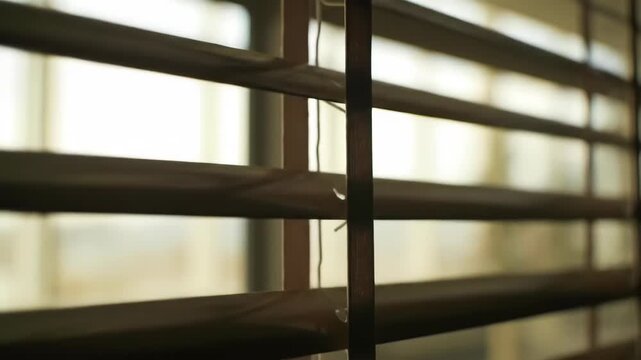 Wooden blinds with sun shining through slats in morning light