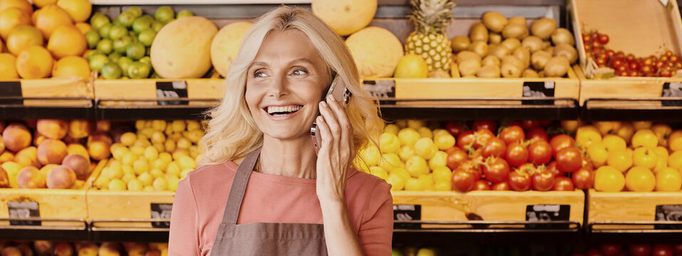 Saleswoman engages shoppers while promoting local organic produce in vibrant market